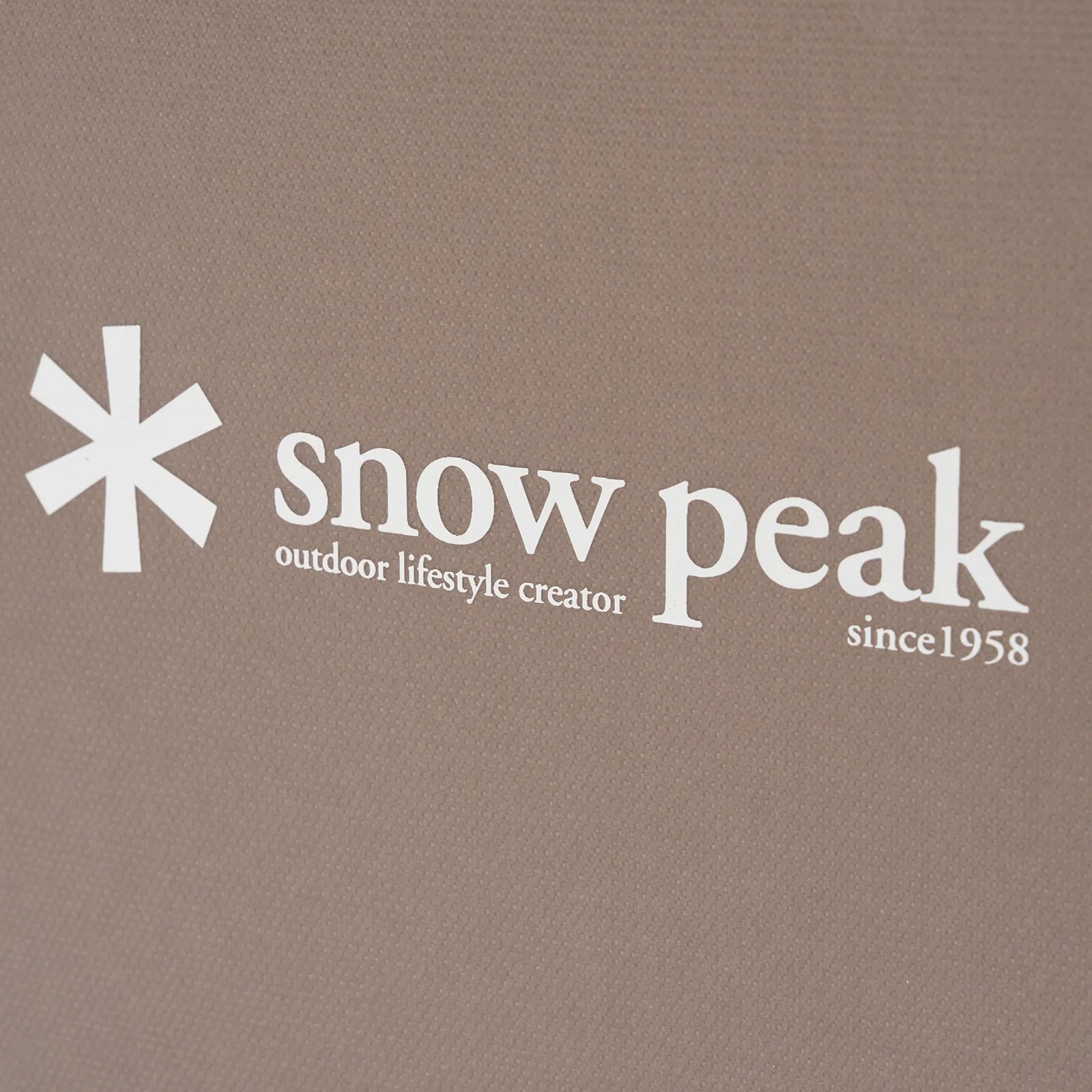 Snow Peak logo on a brown background